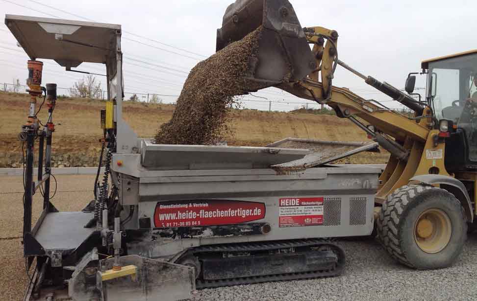 Es können mit unserem Flächenfertiger nahezu alle schüttfähigen Materialien eingebaut werden. Die maximal verarbeitbare Korngröße des Baumaterials beträgt 56 mm.